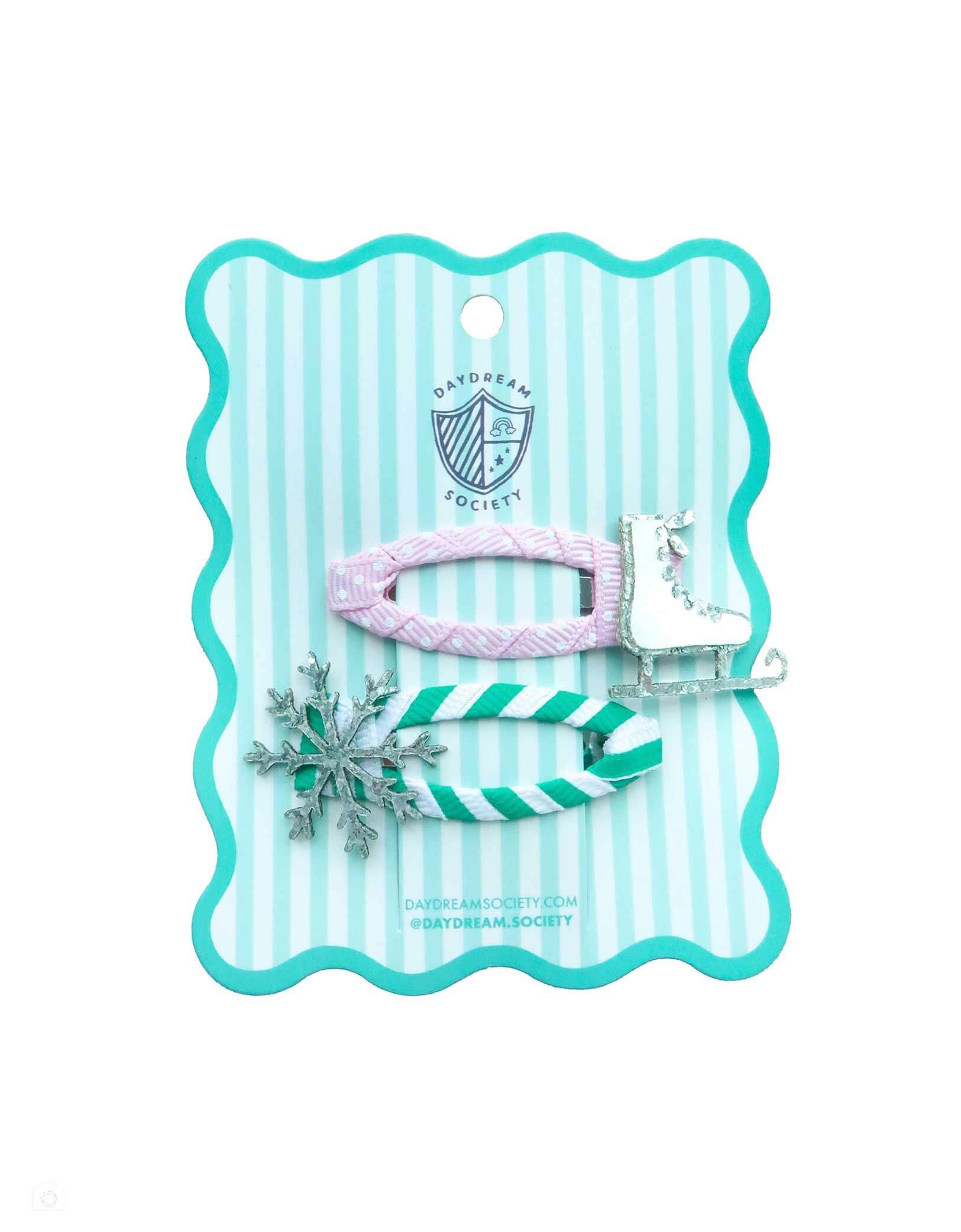Momo Party's Winter Wonderland glittered Snowflake and Ice Skate hair clip set accessories on a striped card with Daydream Society logo on it on a white background.