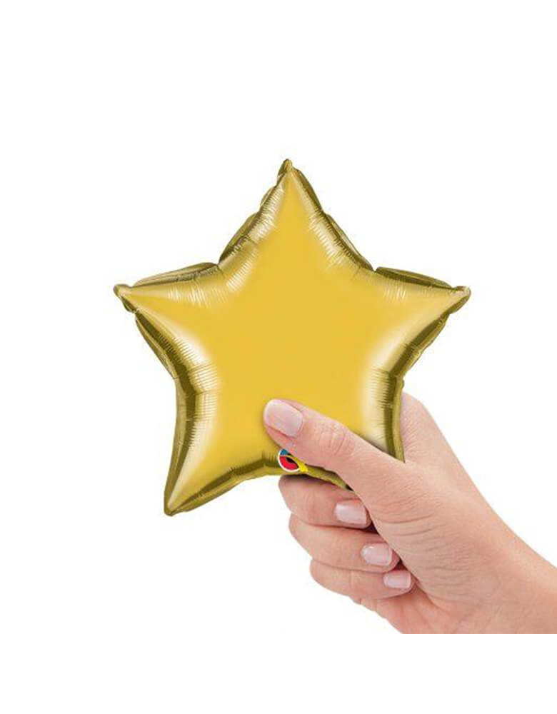 Qualatex Balloons - 9″ Mini Star Shaped Foil Balloon in Metallic Gold color with in hand holding it