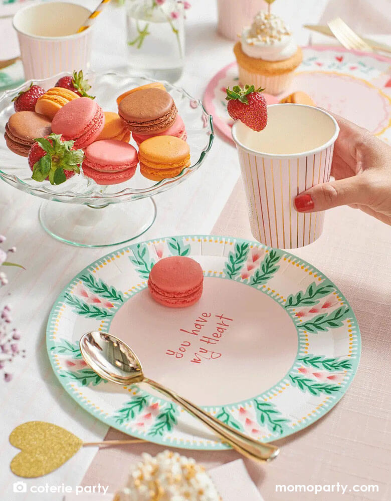 A beautiful love themed party table featuring Momo Party's 9 oz pale pink pinstripe party cups by Coterie Party and 9" All You Need is Love Large Plates with a message of "You have my heart" on the plate. With a tableset with pastel pink themed tableware with heart shaped elements, it's a perfect inspiration for a Valentine's Day celebration.
