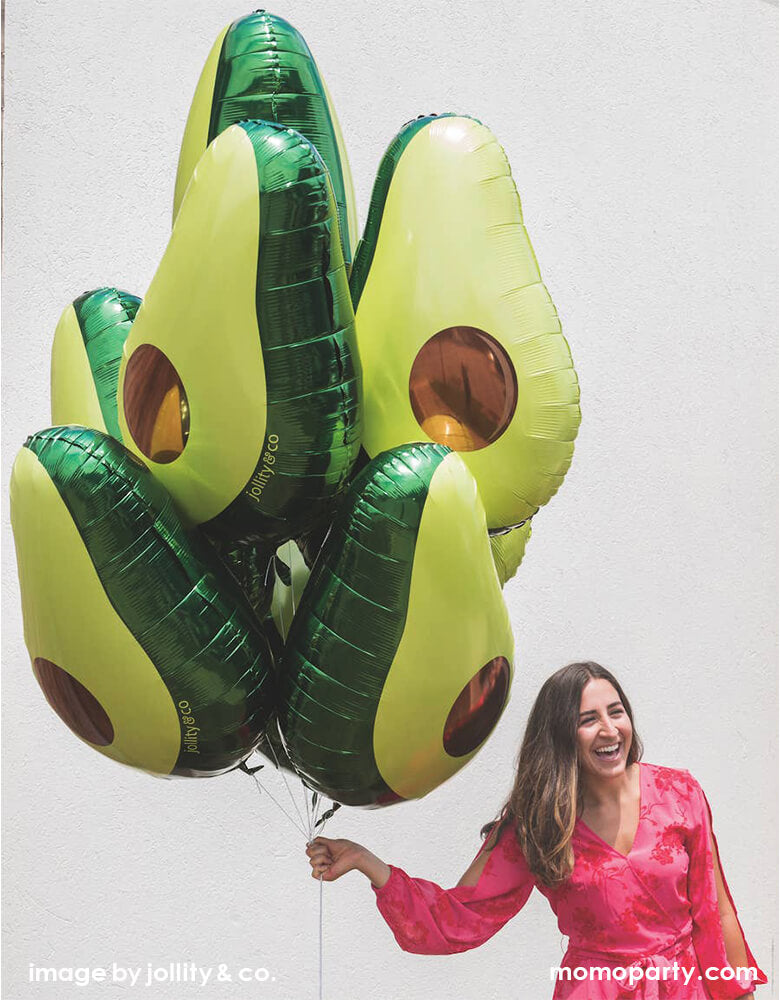 a lady wearing a hot pink dress holding bunch of Jollity & Co. 30 inches Avocado Foil Mylar Balloon. perfect for setting behind the taco bar, celebrating Cinco de Mayo or hosting a fiesta-themed birthday party