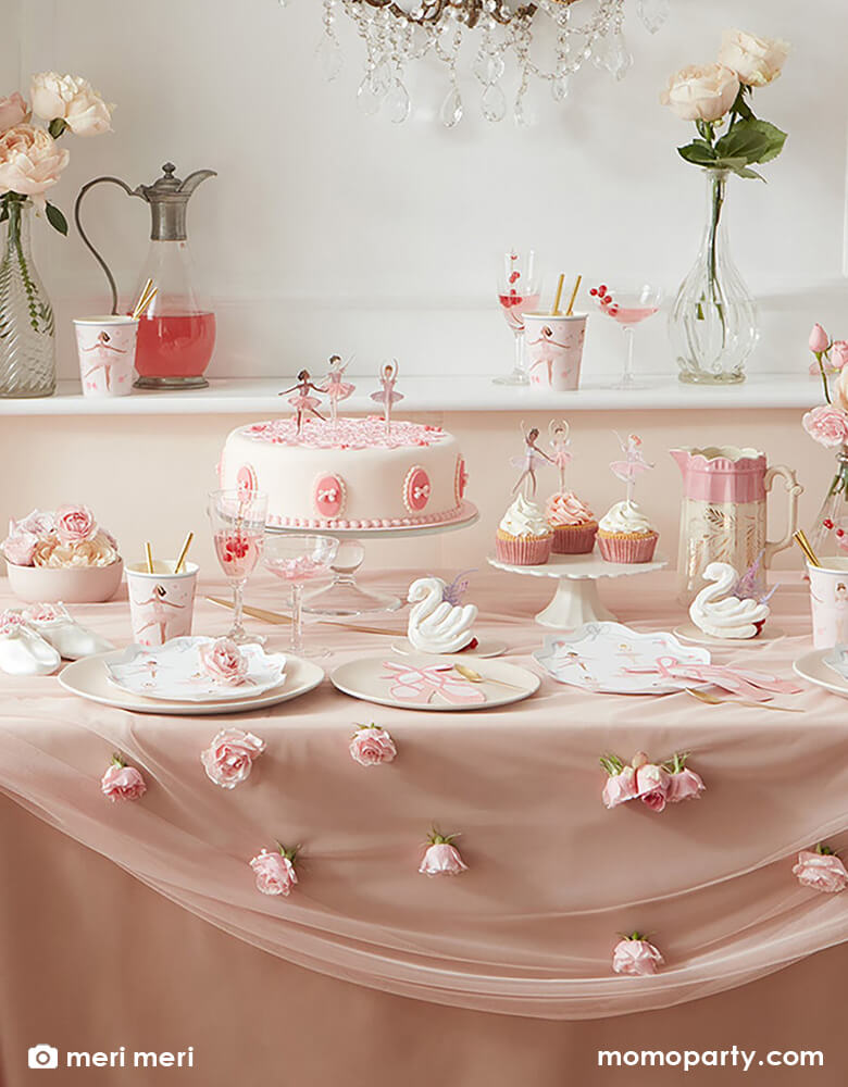 Ballet themed birthday party table setting full of Ballerina Plates from merimeri, Ballet Slippers Napkins, tissues, Ballet paper Cups, cupcakes and cupcakes with cupcake toppers from Ballerina Cupcake kit, flowers, swan decorations, all on a pink and flesh toned silk tablecloth