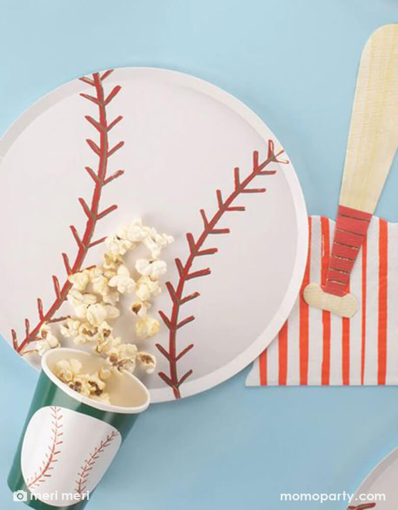 A table set with baseball themed tableware from Momo Party including a 9.5" baseball shaped plate, 4.75 x 7.75" baseball bat shaped napkin and a 9 oz baseball party party cup by Meri Meri. Perfect for kid's baseball themed party or a watch party.