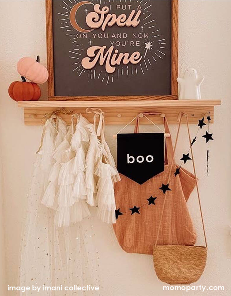 Kid's room wall shelf hanging with girl's beautiful tutu dresses, a black canvas Boo hang Sign, black star banner, Woven bags. And felt pumpkins, a wooden framed poster with "i put a spell on you and now you're Mine" words. a cute white ghost figures. These modern unique halloween product are so fun for your little one's room decoration, party decoration, and instagram worthy photos for you halloween celebration memories. Sell from Party Boutique Online at momoparty.com