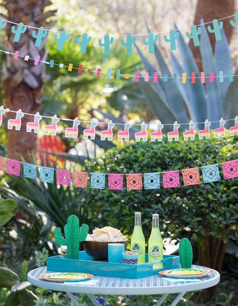 Outdoor Fiesta Cactus Theme birthday party set up with My Minds Eye Cactus Banner, llama banner, Pinata banner, and cactus table toppers for your next Taco Tuesday gathering