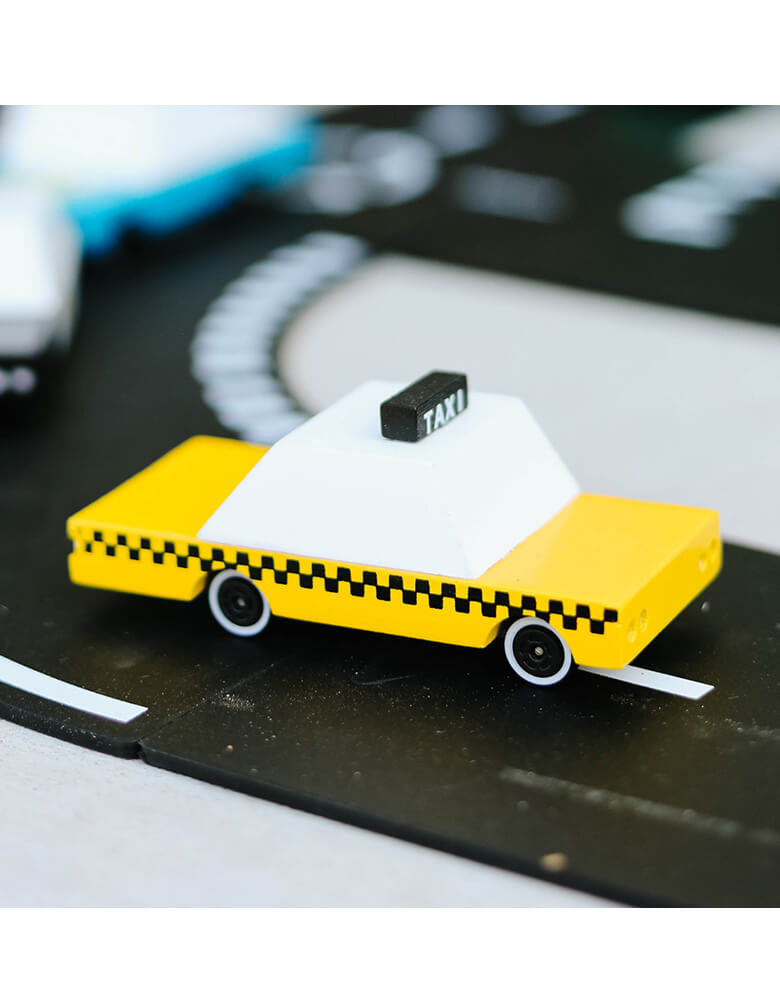 A Candylab Candycar Yellow Taxi on a toy asphalt road