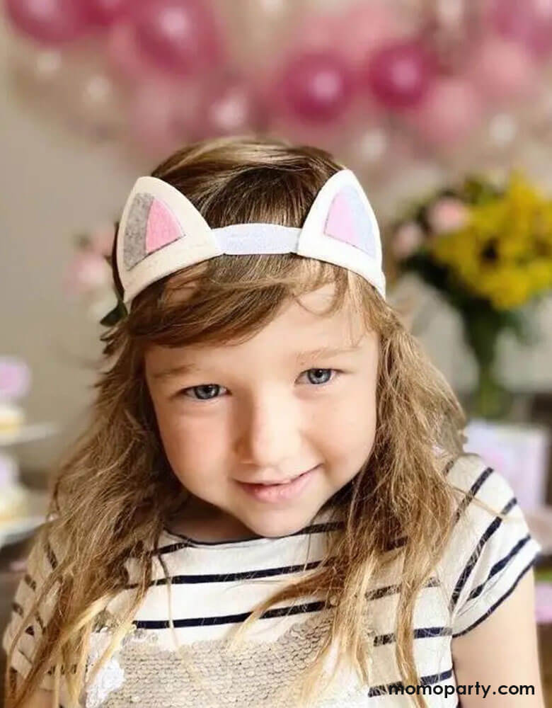 A girl dressed up in Momo Party's felt cat headband in a cat themed birthday party