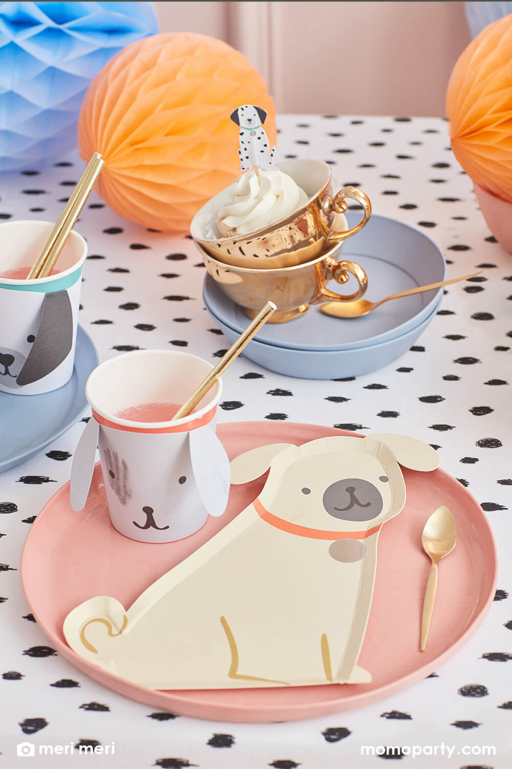 Momo Party kid's puppy dog themed birthday party table, filled with Pug Plates on a croal round plate, Puppy Cup with gold foil straws,  Puppy cupcake topper on the cupcake in the cups, honeycombs all on the black dots tablecloth,  The modern and cute design party supplies from Meri Meri of Cat and Dog Collection,will make an Insta-perfect party table for your kid's puppy or dog themed birthday party.