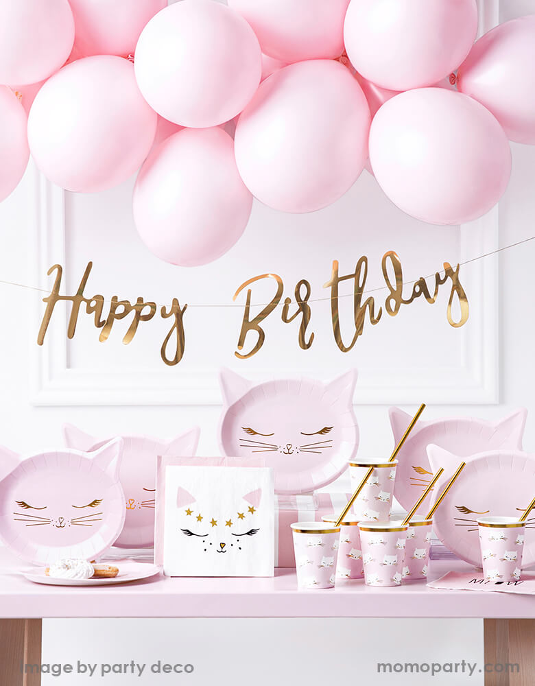 Pink kitty cat birthday party supplies, decorated with pastel pink balloon garland, Gold foil happy birthday banner, Party Deco pink cat plates,, kitty cat napkins, Kitty cat cups with gold foil straws on the pink table. These pretty in pink cat themed party supplies are prefect for girls birthday, cat lover's birthday, pet themed party