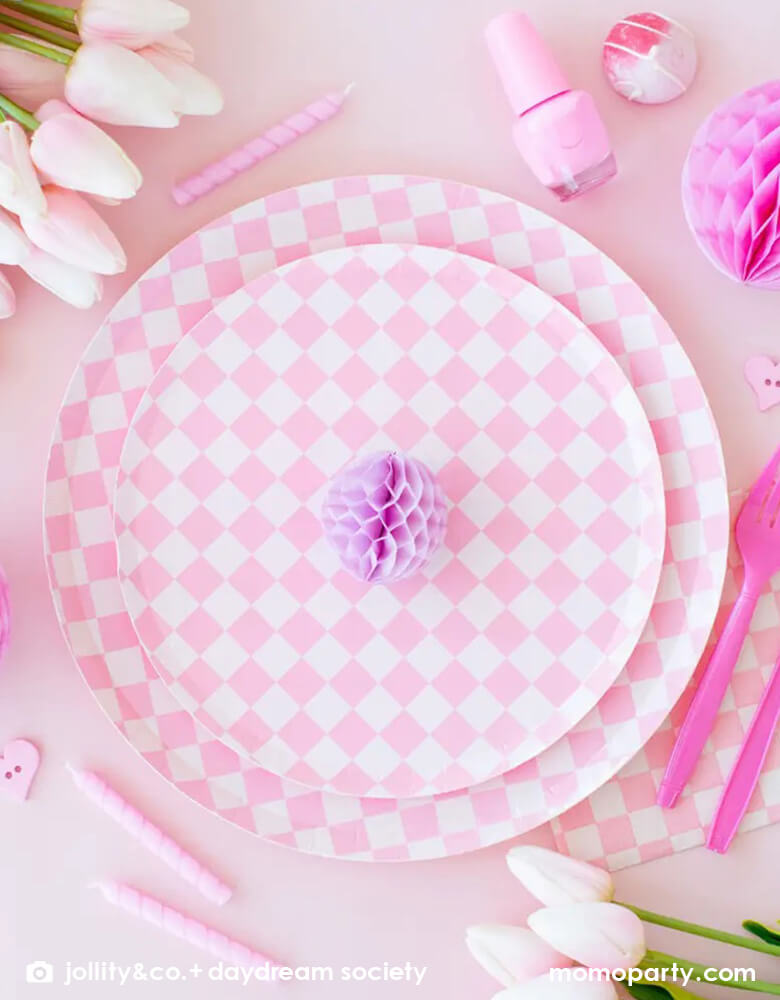 A beautiful set pink table featuring Momo Party's Check it! Pink Check it! Collection by Jollity & Co. including pink checkered patterned dinner plates, dessert plates, and large pink checkered napkins, around the tableware, it was decorated with some pretty tulips, pink nail polish bottle, some pink birthday candles and honeycomb decorations. All in all makes a great inspiration for a girly themed celebration.