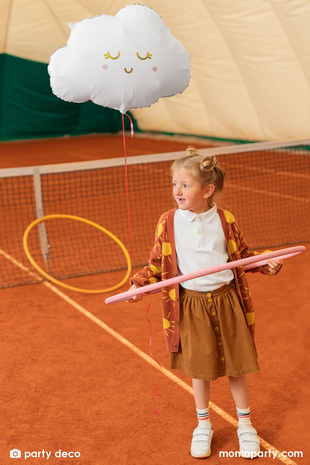 A little girl with hula hoops in a field with party deco's 20" satin/matte cloud shaped foil balloon with gold foil details in her back 