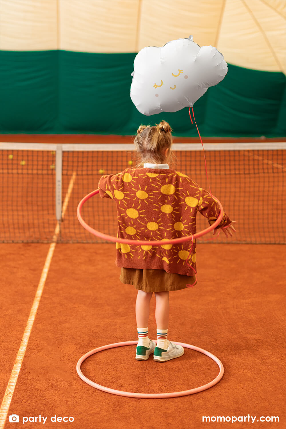 A little girl with hula hoops in a sweater in shiny sun designs in the background with party deco's 20" satin/matte cloud shaped foil balloon with gold foil details