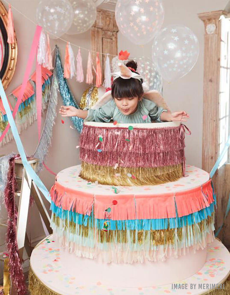 Kids Birthday party with a birthday cake decorated with Meri Meri's Colorful Fringe Large Garland
