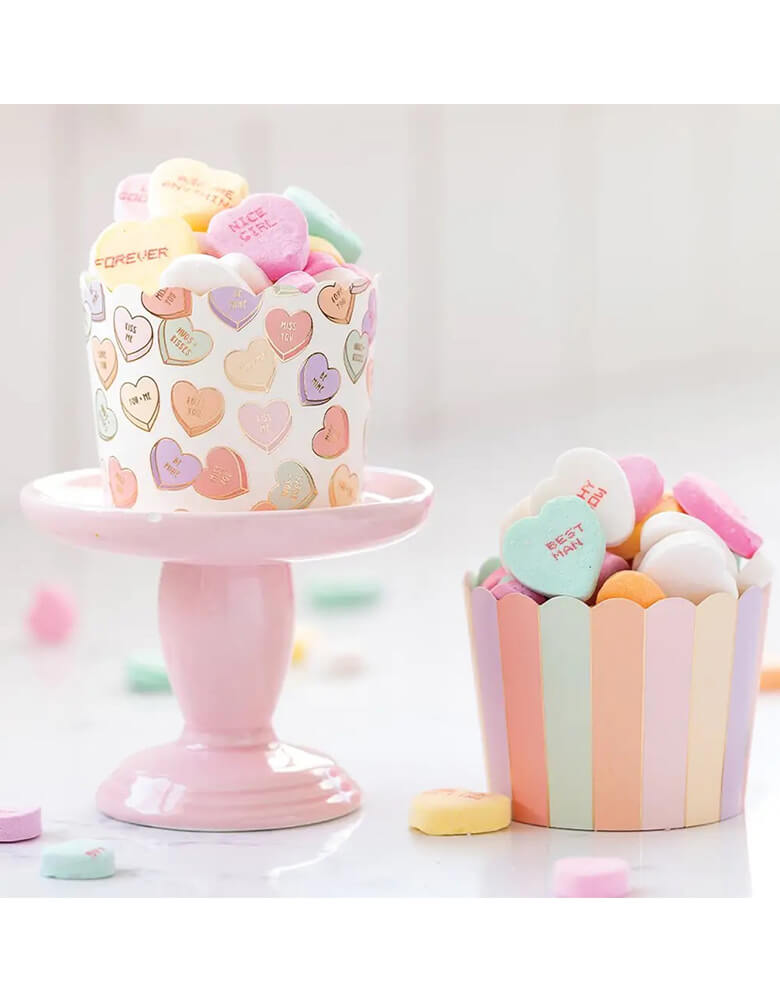 Momo Party's 5oz Gold Foil Conversation Hearts Baking Cups set of 50 by My Mind's Eye, filled with conversation heart candies, an adorable set up for a Valentine's Day celebration.