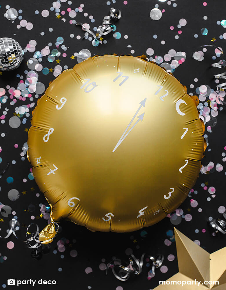 Momo Party's 14" countdown clock shaped foil balloon in gold by Party Deco surrounded with multicolor confetti and small disco balls, a perfect balloon decoration for New Years Eve celebration