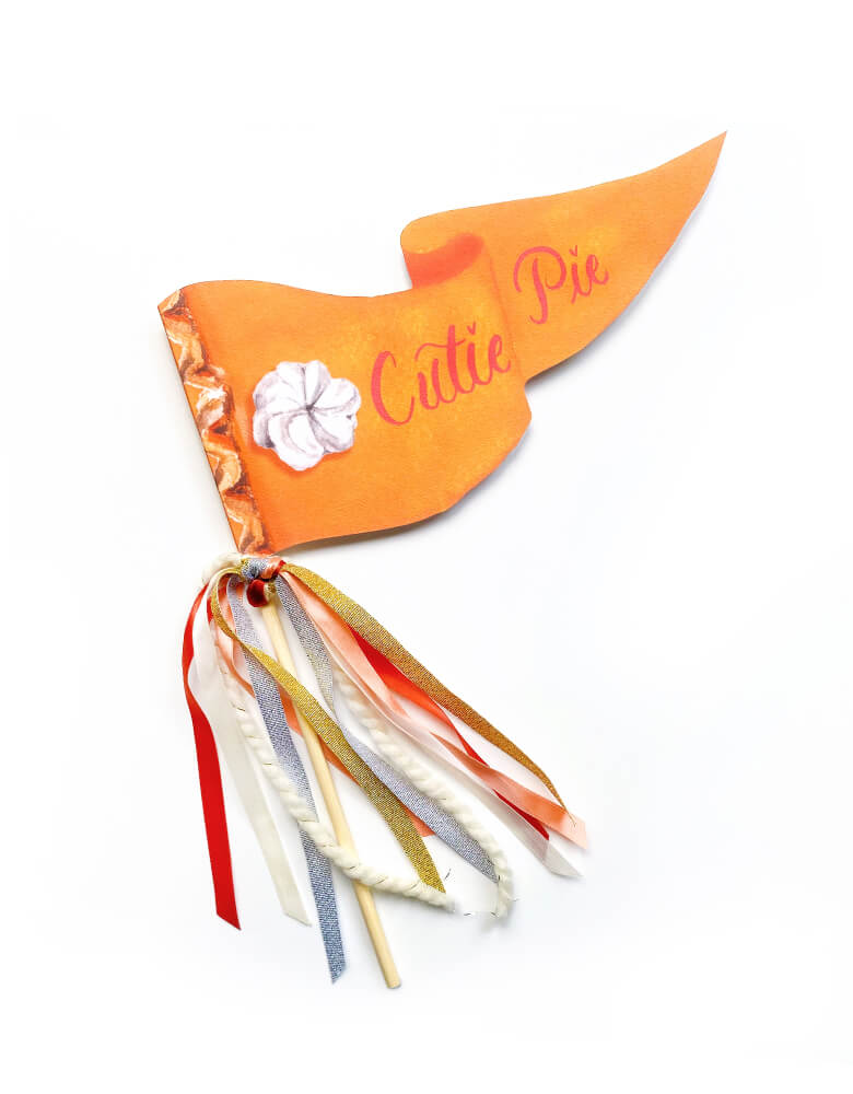 Cutie Pie Pumpkin Pie Thanksgiving Party Pennant by Cami Monet. This 10 x 5 inches handmade pennant featuring a handwriting "Cutie Pie" text and a cream pie illustration, with watercolor background in orange on the 120 lb. luxe watercolor texture paper, with orange, red, silver Ribbon and sparkle garland adding details on the rod. This high quality made party pennant is so cute for celebrating Thanksgiving ! Hold it in a photo or pop on a cake or use as your Thanksgiving parties and fall celebrations