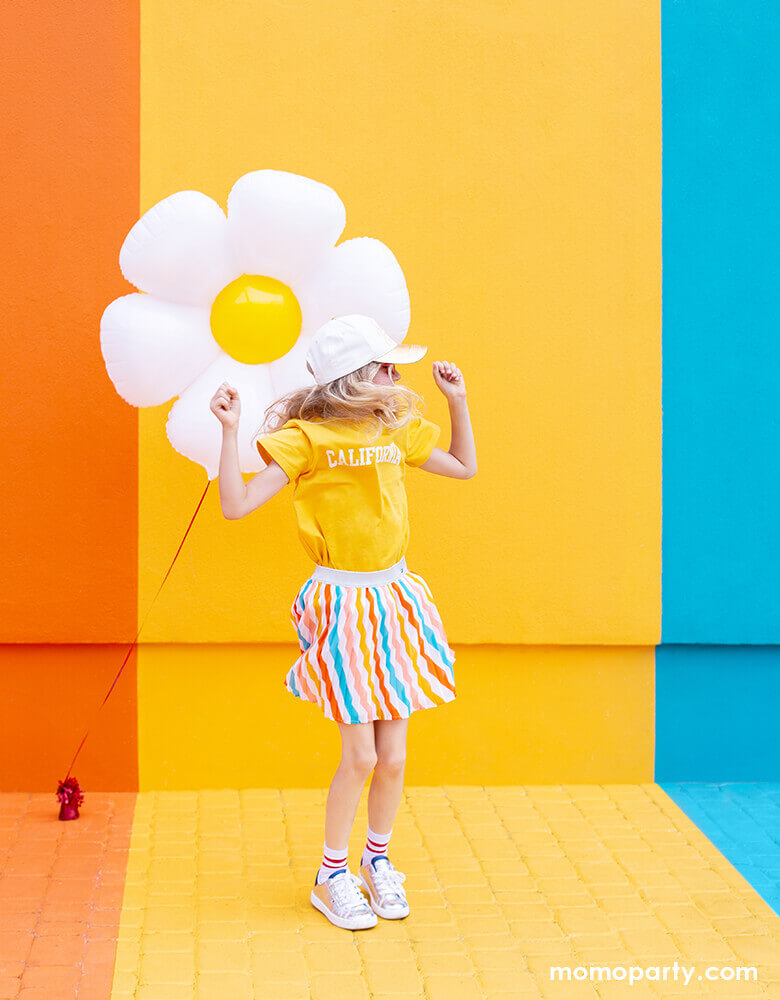 little girl dance in front of colorful painted wall and with Party Deco Daisy Foil Mylar Balloon. this this adorable Daisy petal shapes foil mylar balloon bright your spring or tea party themed celebration