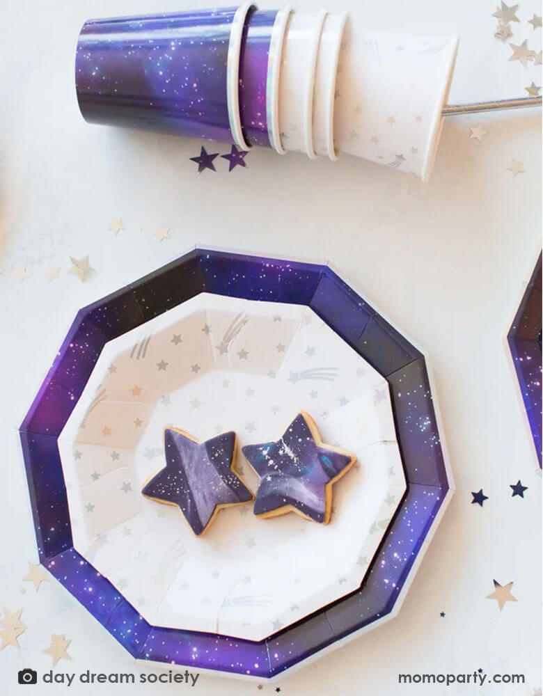 Daydream Society 9" Galactic Large Plates pairing with over the world silver foil shooting star plates with matching party cups next to them, perfect decorations for a space birthday party or a Star Wars themed party