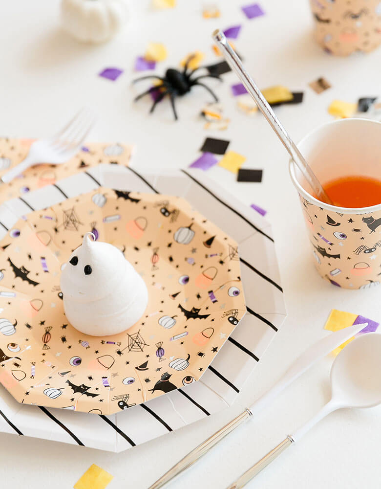 Daydream Society Hocus Pocus Halloween tableware including plates, cups, napkins on a festive Halloween party table with confetti and Halloween spider decorations and Halloween themed treats for kids