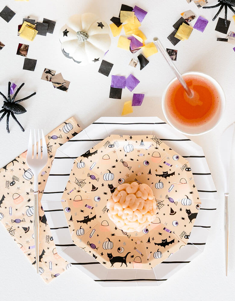 Daydream Society Hocus Pocus Halloween tableware including plates, cups, napkins on a festive Halloween party table with confetti and Halloween spider decorations and Halloween themed treats for kids