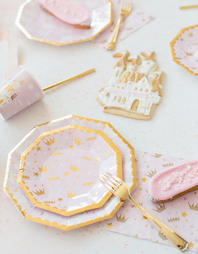 Daydream Society Sweet Princess party collection including party plates, cups, napkins on a pink party table filled with confetti and castle design cookies for a girl's princess themed birthday party