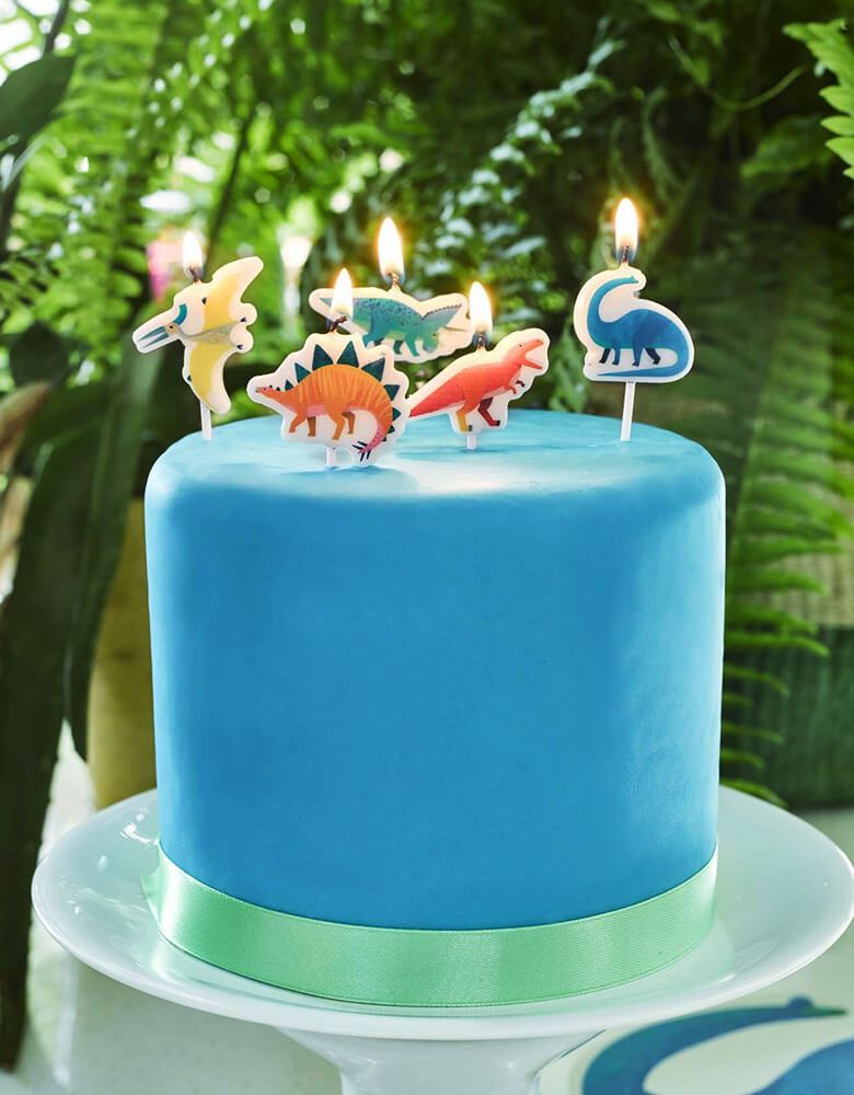 Dinosaur Birthday Candles on top of blue cake