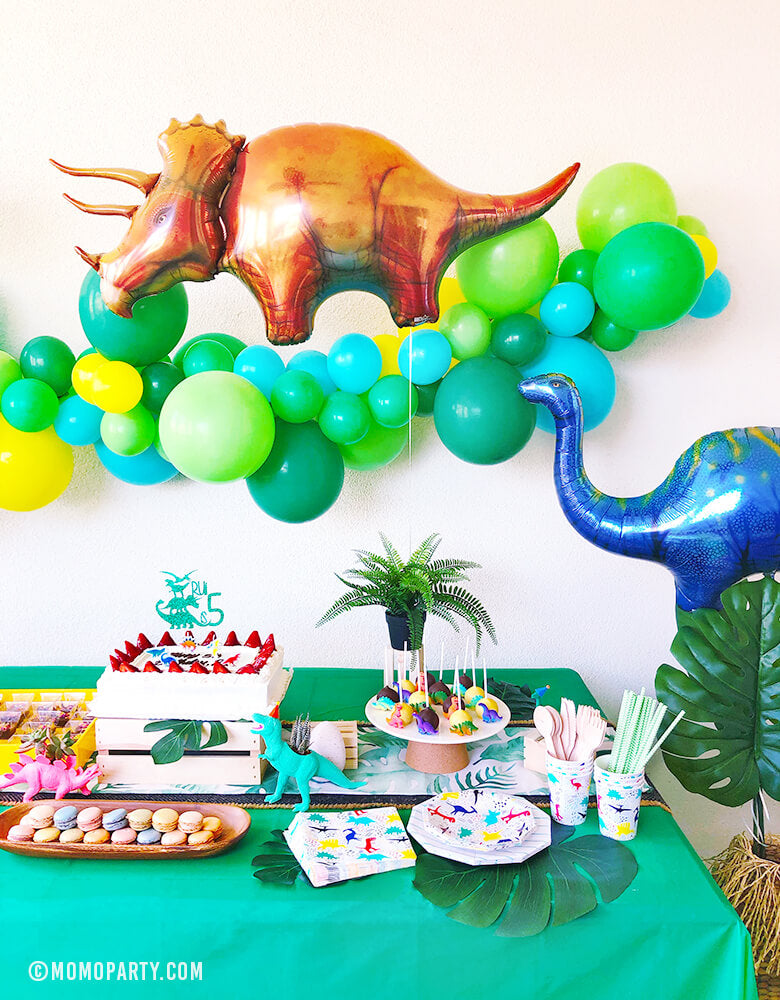 Kids Dinosaur Party Set up with dark green, blue, mint, yellow latex Balloon Garland, Dinosaur foil balloon, neon dino planner, table wears, sweets as table decorations, 