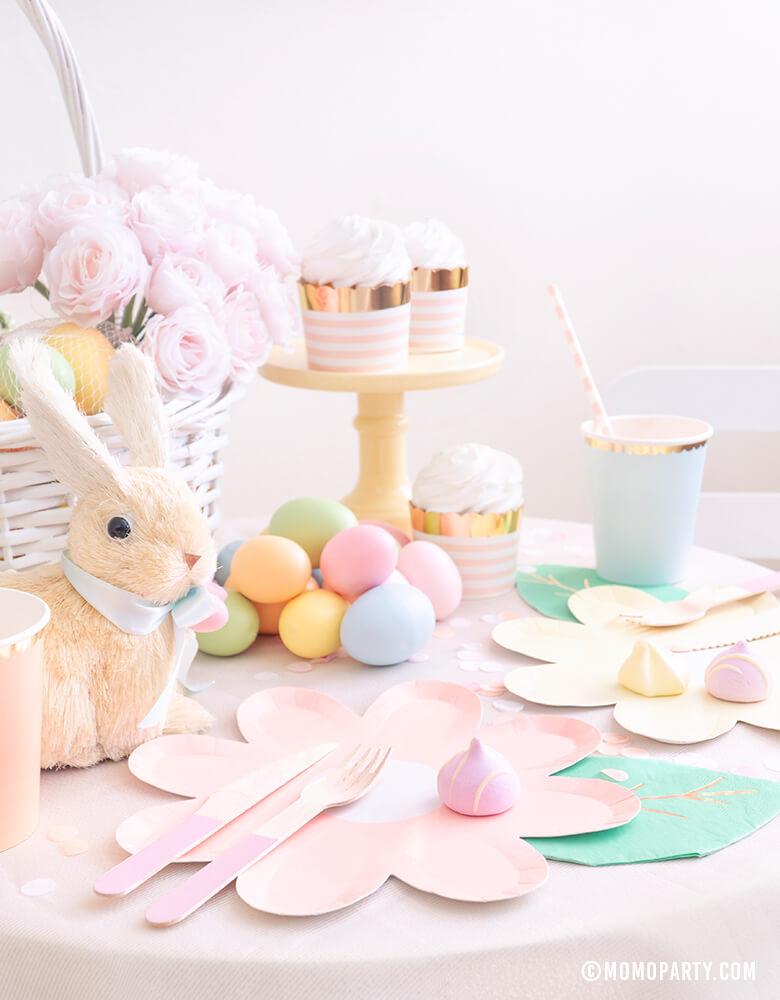 Modern pastel Easter Party dessert table with Pastel Daisy Large Plates, Pastel Cups, Leaf Napkins and Easter Basket and pastel eggs, bunny decoration, and sweets 