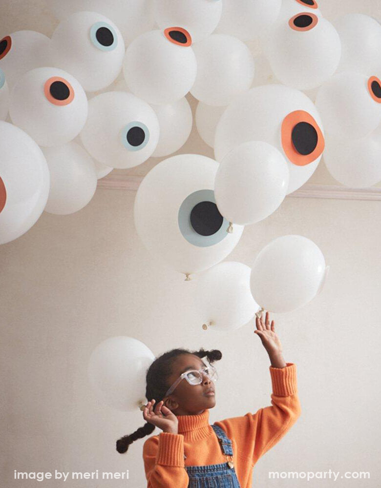 girl looking up touching Meri Meri - 217117_Eyeball Balloon Garland