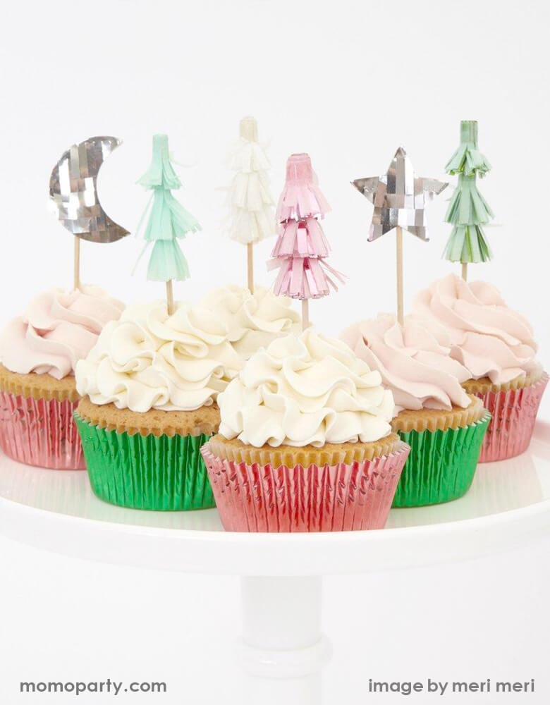 A Set of cupcakes topped with Meri Meri Festive-Tree-Cupcake-Kit featuring Christmas tree, moon and star toppers in pink silver and mint foil