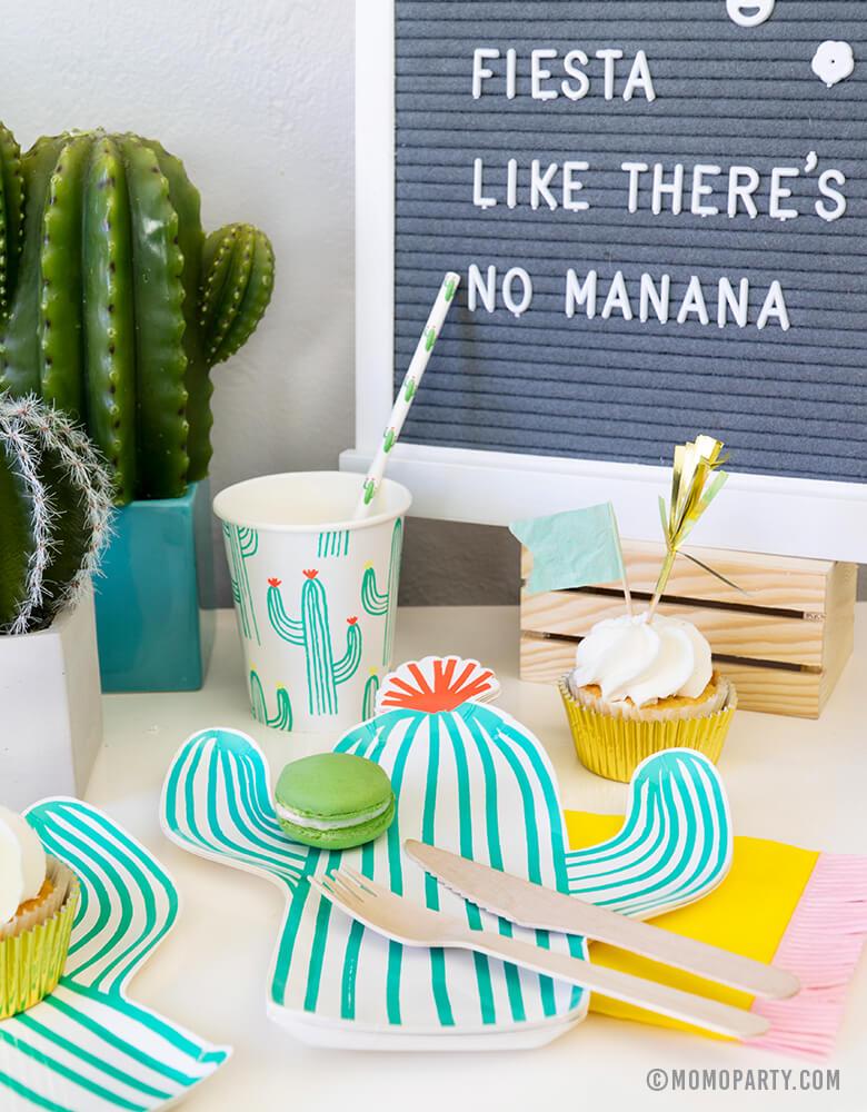 Fiesta Cactus Theme party set up dessert table with Macaron on the Cactus die-cut plates, Cactus paper cups and Cactus printed straw, cupcakes, mini cactus planter,  and letter board with writing in "Fiesta Like There's No Mañana""