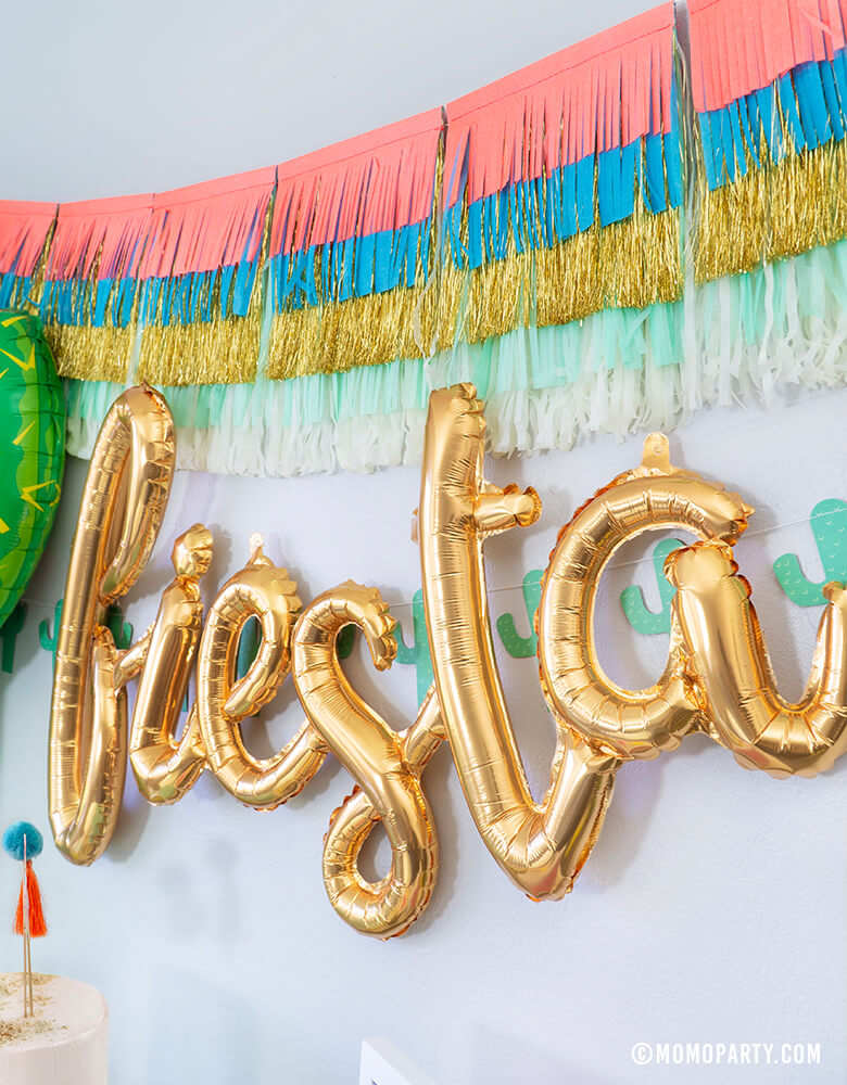 Fiesta Cactus Theme party backdrop inspiration with Meri Meri Colorful Fringe Large Garland, Fiesta Gold Script Mylar Balloon, My Mind's Eye's Cactus Banner