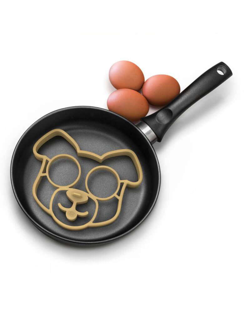 Genuine Fred Funny-Side-Up-Dog-Egg-Mold on a pan with eggs
