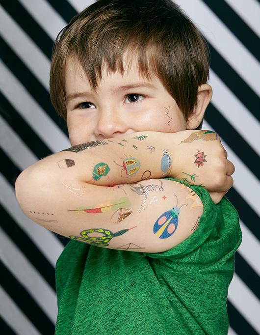 boy showing lots of cool Temporary Tattoos on his arm