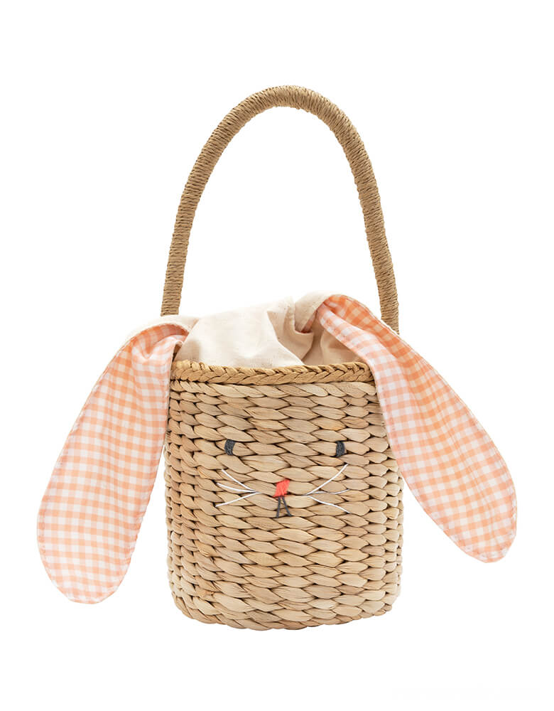 Meri Meri - Gingham Bunny Straw Easter Basket. it has a sweet bunny face, a peach gingham cotton lining, fun floppy ears and a cute pompom tail. Perfect as an Easter basket, or for any special occasion where an adorable accessory will add style.