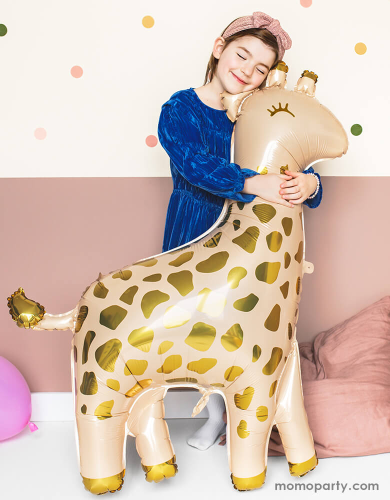a girl with blue dress hugging a 40 inch Giant Smelling Giraffe Foil Mylar Balloon by Party Deco . This adorable giraffe shape foil mylar balloon in cream color with gold metallic prints is perfect for your little one's safari or zoo themed celebration, Nursery room decor, animal party, baby shower ect