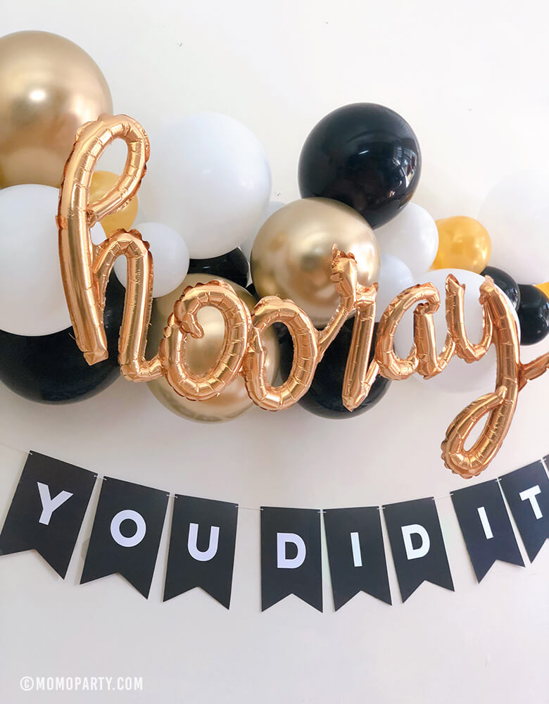 Black, gold and white balloon garland with Hooray Gold Script Mylar Balloon, and Black customized letter banner spelled with "you did it" for a modern graduation celebration.