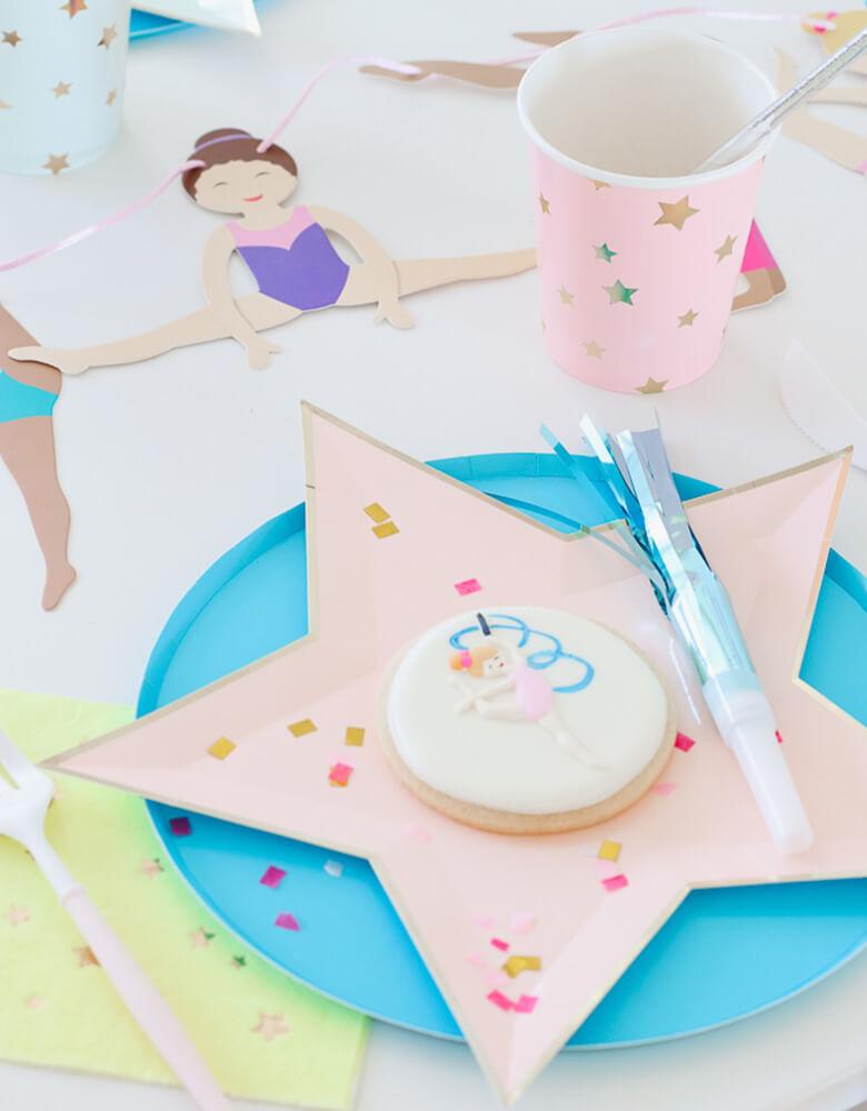 Girl's Gymnastics Themed Party Tablescape with Meri Meri bright die-cut star plates, Oh happy day Blue paper plates, and colorful jazzy star cups, Gymnastic girl cookie, light blue blower 