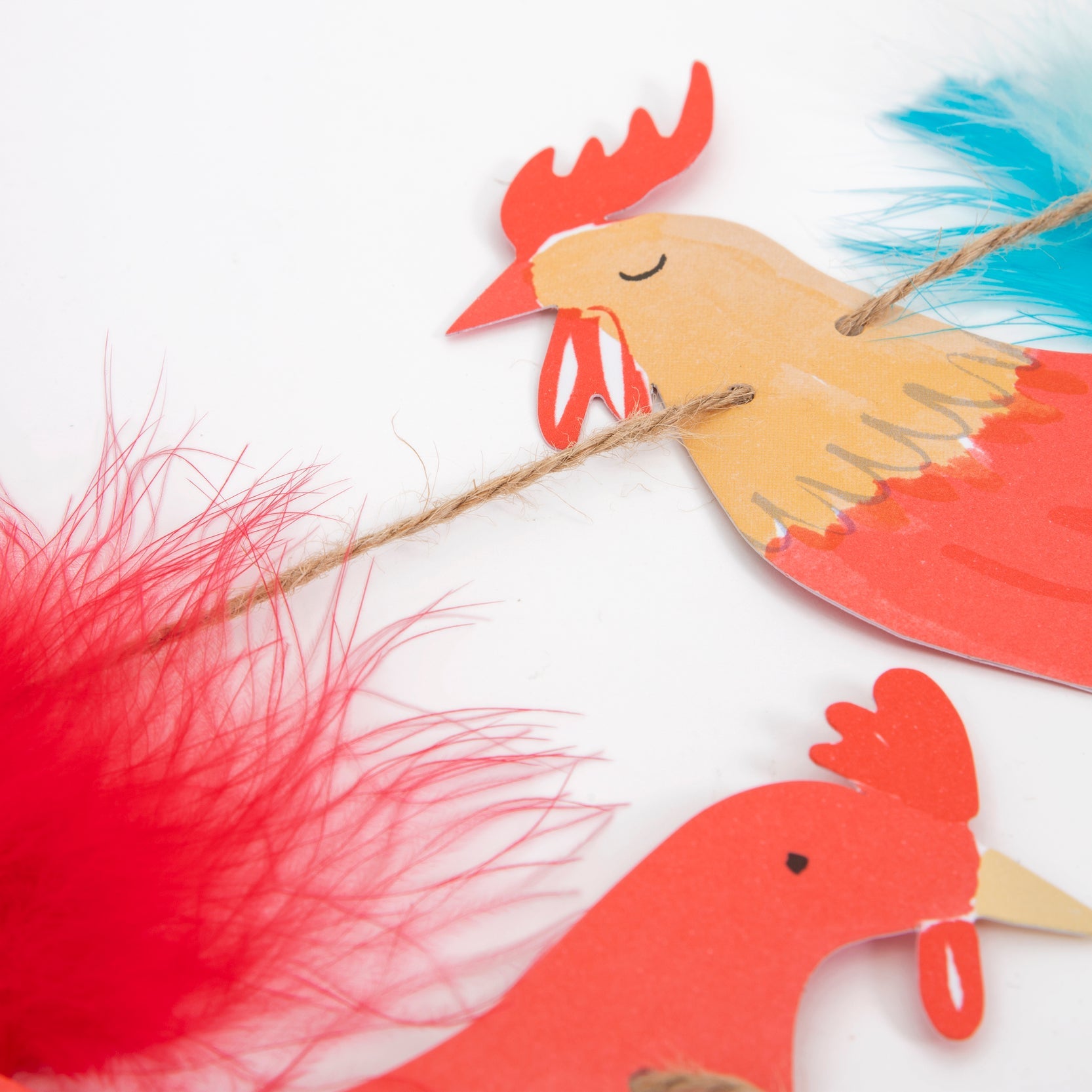 Detail look of Meri Meri On The Farm Large Garland. With Feather & raffia on the Beautifully illustrated and crafted rooster pennant. This high quality and designed party garland is so fun for kids farm themed birthday party, decoration in their room.