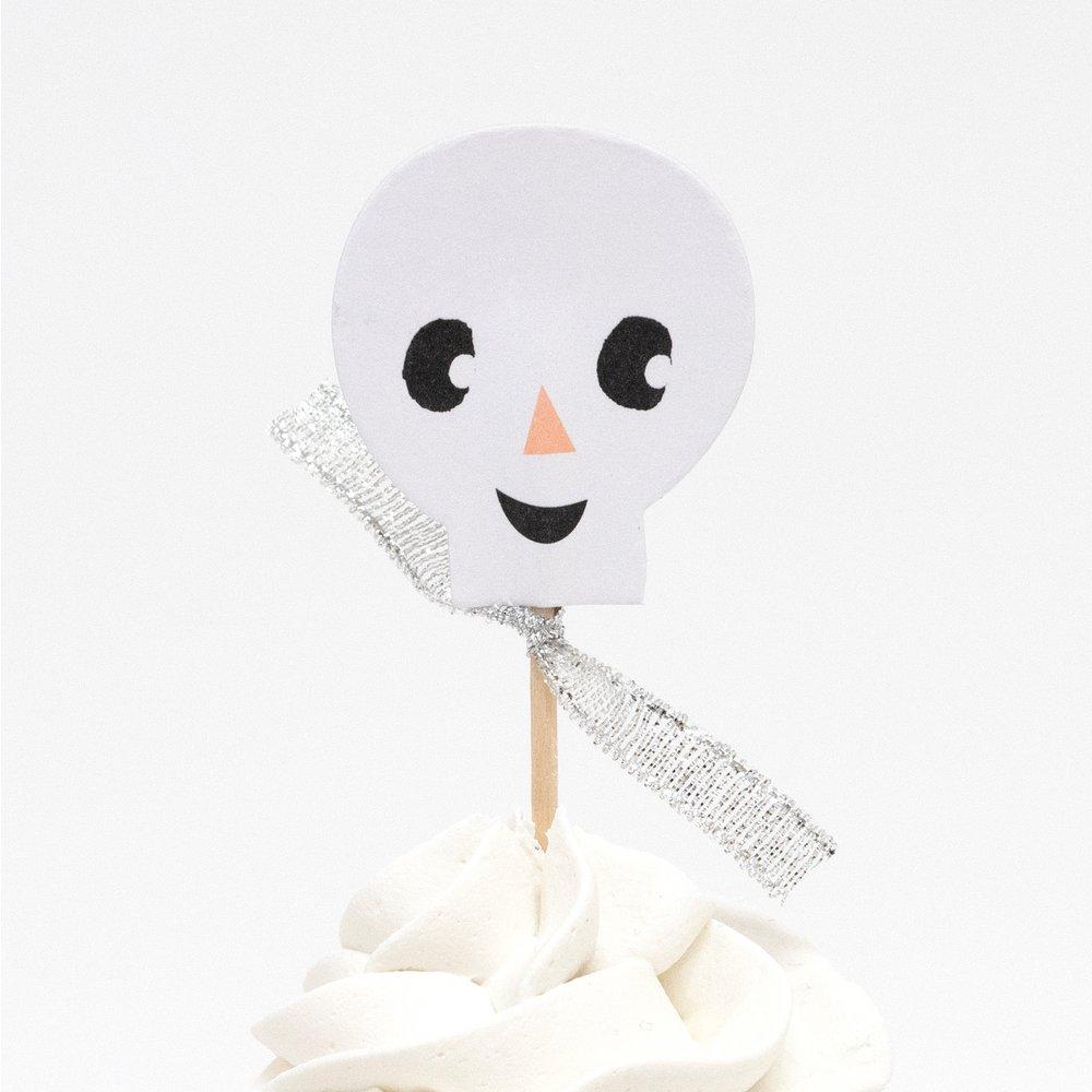 Cupcakes decorated with skelton topper of Meri meri Pastel Halloween Cupcake. With silver ribbon embellishments in a happy skelton shape, This cupcake kit is perfect to create the most amazing Halloween treats.