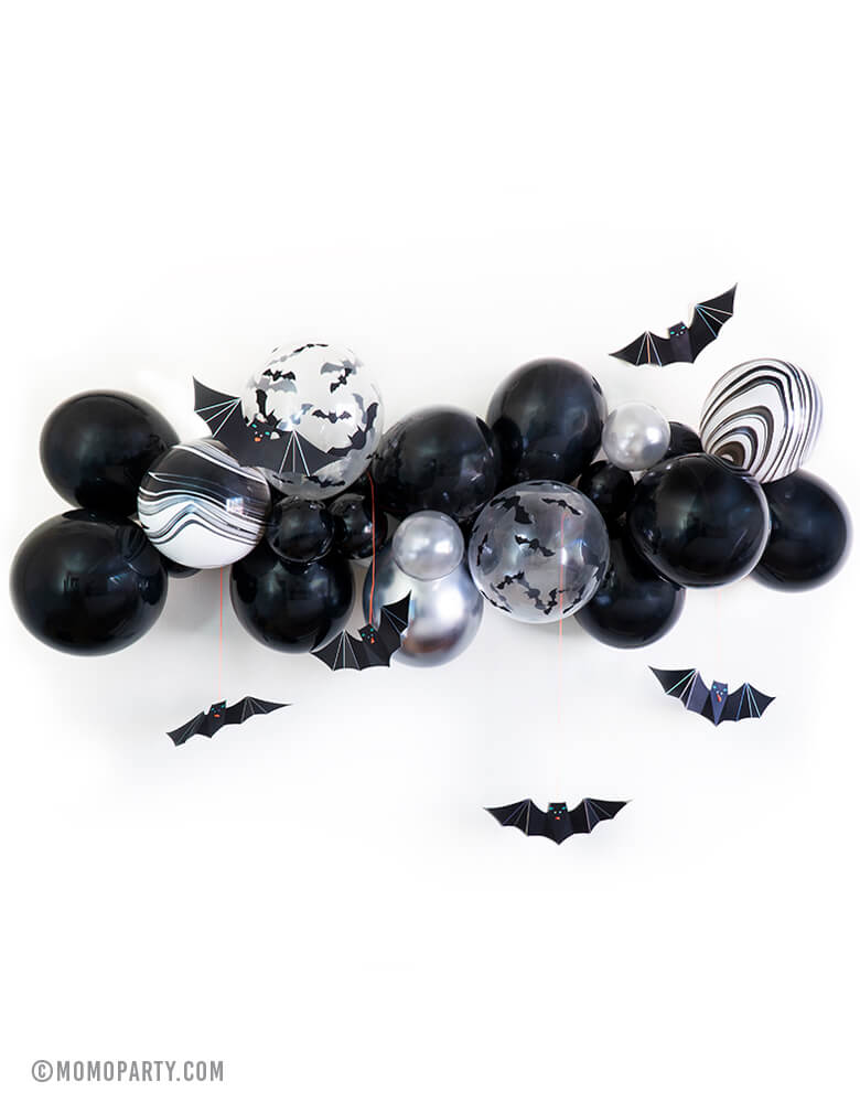 Momo Halloween Bat Balloon Cloud, Balloon Garland with Meri Meri hanging bats decoration. Balloon garland assorted with 11inch and 5inch Halloween-themed latex balloons in black, white, clear bat print, black and white agate, chrome silver and silver, made in USA. Party backdrop, wall decoration for a kid-friendly modern spooky halloween party, Bat party, trick-or-treating halloween party, nightmare before Christmas party, witch themed party, Halloween birthday party and all halloween related celebrations