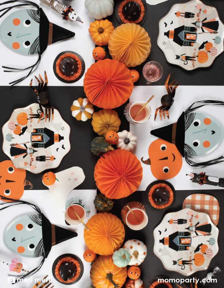 A fun Halloween Party table featuring Meri Meri's latest Halloween tableware which includes Meri Meri 10.25" Halloween pumpkin patch dinner plates featuring happy Halloween icons including a witch, a friendly skeleton, a scarecrow, a black cat, a haunted house, bats and pumpkins with stylish gingham print details, and Halloween shades of black and orange, perfect for a not-so-spooky kid's friendly Halloween party