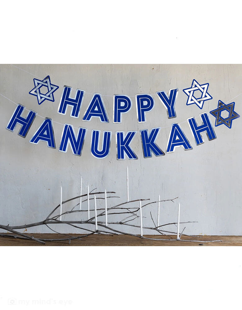 Momo Party's 3 yard Happy Hanukkah Banner by My Mind's Eye, featuring the message "Happy Hanukkah" in festive silver foil and rich blue, it's perfect to dress up a mantel or tablescape for your Hanukkah celebrations.