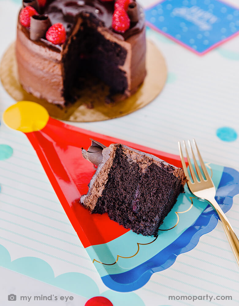 A slice of chocolate birthday cake on My Mind's Eye Blue Birthday Hat die-cup Shaped Plates with gold foil accent, perfect for a boy's birthday party celebration.