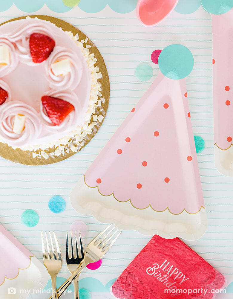 A darling birthday party table with a pink strawberry buttercream birthday cake, filled with cheerful confetti in mint, coral and yellow and My Mind's Eye coral scalloped Happy Birthday napkins with pink birthday hat shaped party plates - a perfect size for serving birthday cakes - all makes a great modern and simple inspiration for a girl's birthday celebration.