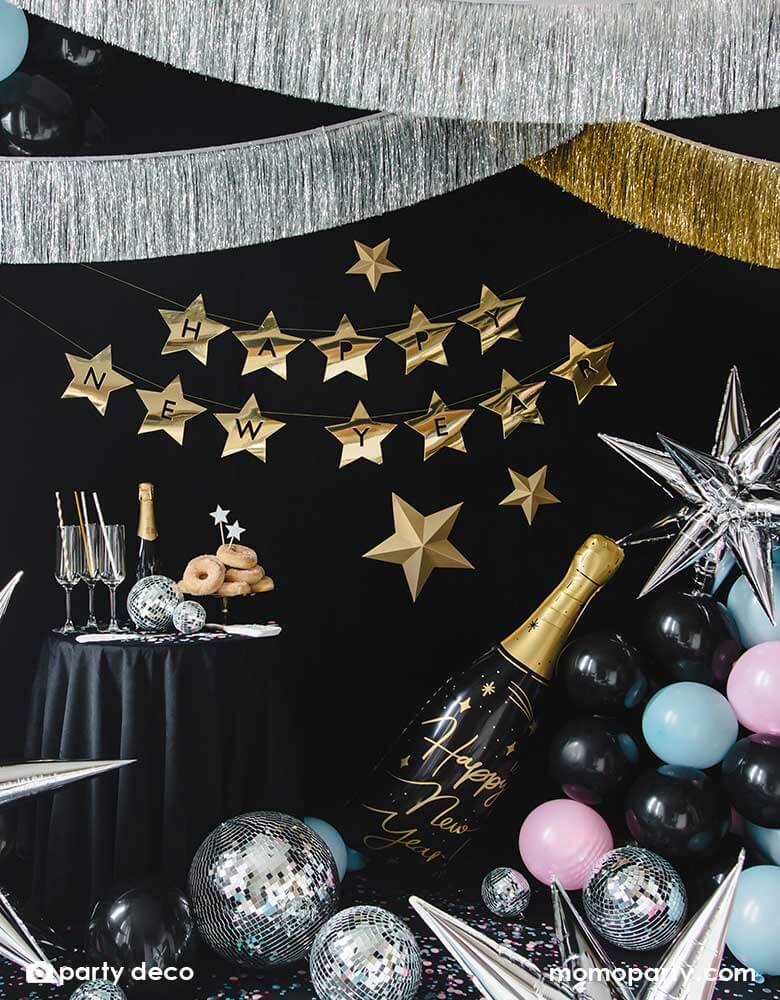 A New Year's Eve countdown party decorated with Momo Party's gold and silver tinsel garlands and various Happy New Year themed balloons including a champagne bottle shaped foil balloon, silver starburst balloons, and disco ball decorations 