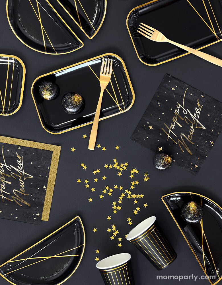 Black and gold new year party table top view with Party Deco - Happy New Year Large Napkins, black and gold foil special shaped party plates with gold foil truffle chocolate on it, black paper cup with gold stripe print with gold stars confetti in a black table top. Ring in the New Year in style with this gorgeous Happy New Year party collection with gold foil detail. This black and gold new year collection is the perfect party tableware for a new year party!