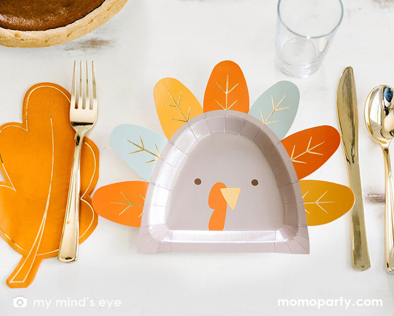 Thanksgiving Table set up with My mind's Eye - THP844 - HARVEST TURKEY SHAPED 9" PLATE, Thanksgiving Gold Oak Leaf Napkins, pie and golden utensils. These modern designed party supplies are perfect for thanksgiving, holiday celebration. Perfect to try one of every flavor of pie, these plates make for a bright holiday experience. Or keep the kids gathered around the kid's table for seconds with these fun turkey plates.