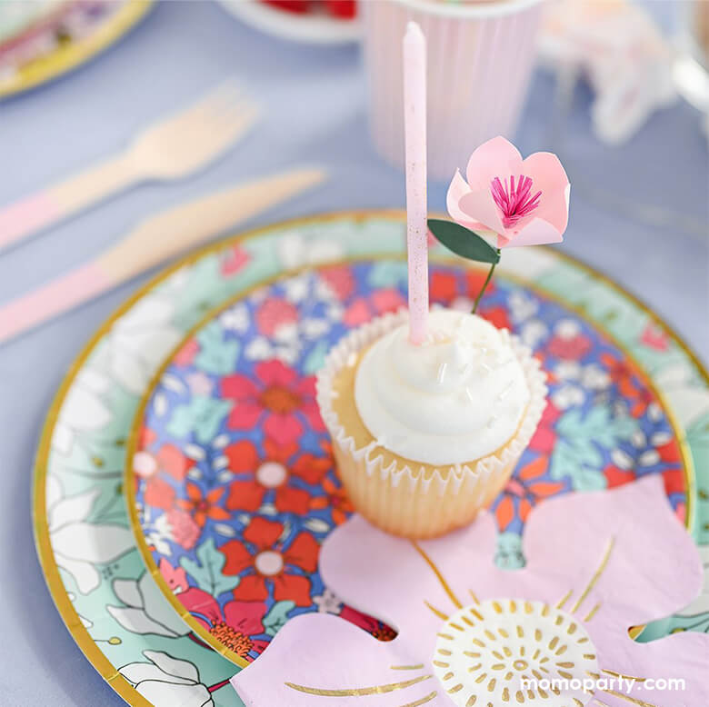 Floral Garden themed party close up look of a cupcake decorated with Coterie In Full Bloom Mini Topper and pink glitter candle on top of In Full Bloom plates and In Full Bloom flower shaped pink Napkin. This garden-inspired modern design are perfect for spring party, garden themed party, fairy themed party, mother's day, bridal shower, baby shower or any morden parties.