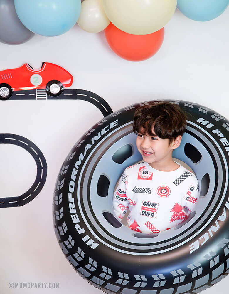 Boy is playing with Intex Inflatable Giant Tire Tube at Race Car Themed birthday party