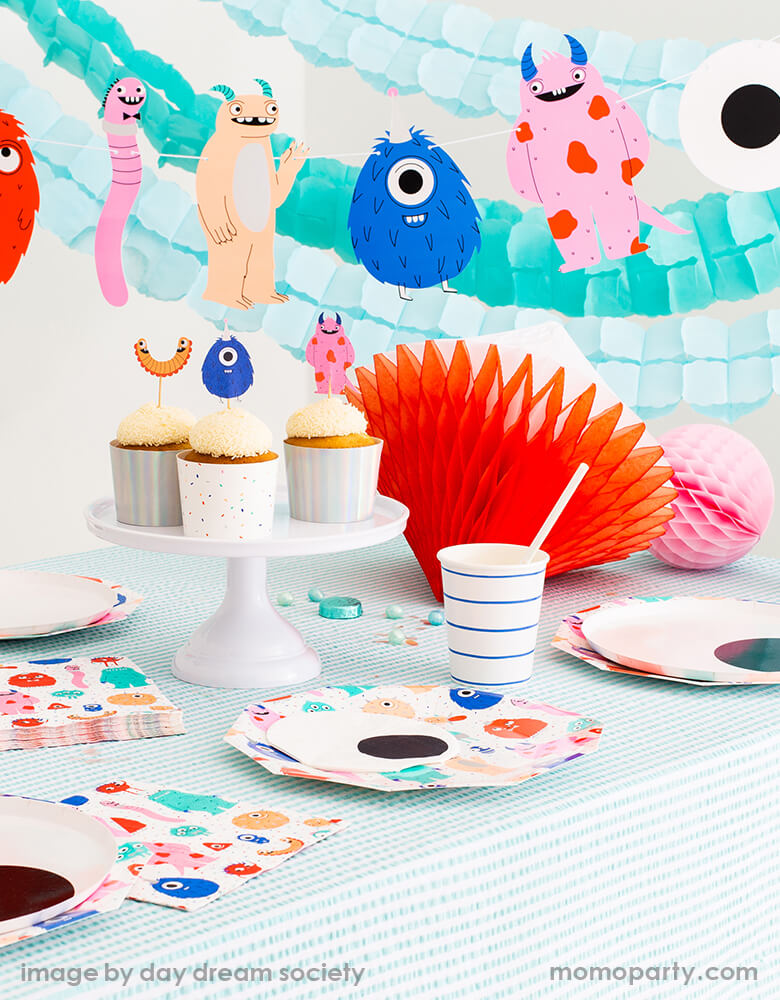 Monster Party table look of cupcakes on a white cake stand with Little Monsters Cupcake Decorating toppers by Jollity & Co Party Boutique - Daydream society collection. Little Monsters Large Plates, with eyeball napkin, blue stripe cups, and colorful honeycomb on the mint stripe tablecloth, mint and light blue Crepe Paper Streamers with little monster garland as backdrop. Super modern cute collection for Little Monsters themed birthday party, halloween party or monster inc themed birthday party